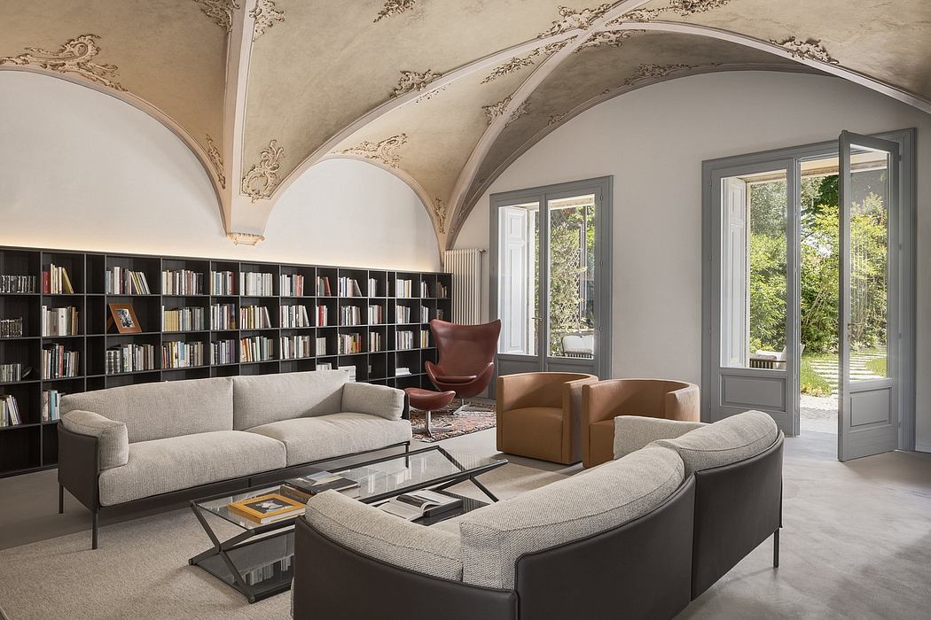 An ornate, vaulted ceiling frames a modern, minimalist living room with built-in bookcases.