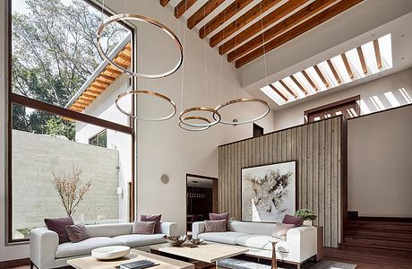 Luxurious modern living room with sleek wooden beams, circular lighting fixtures, and an expansive window.