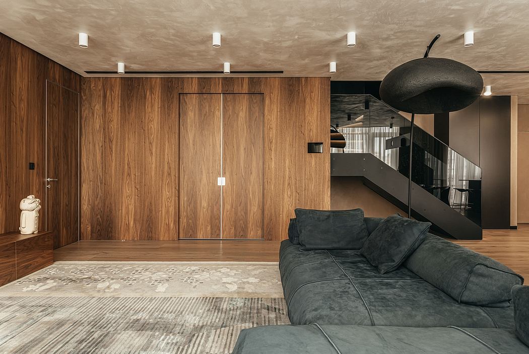 Stylish modern interior with wooden paneling, dark sofa, and unique pendant lighting.