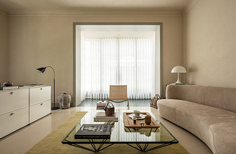 Cozy living room with neutral tones, modern furniture, and abundant natural light from large window.