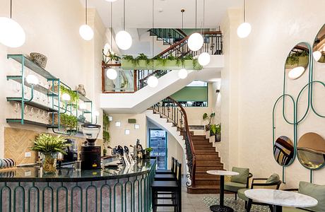 Sleek and modern interior design with metallic accents, spiral staircase, and lush greenery.