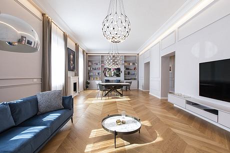 Elegant living room with herringbone wood flooring, chandelier, and built-in shelving.