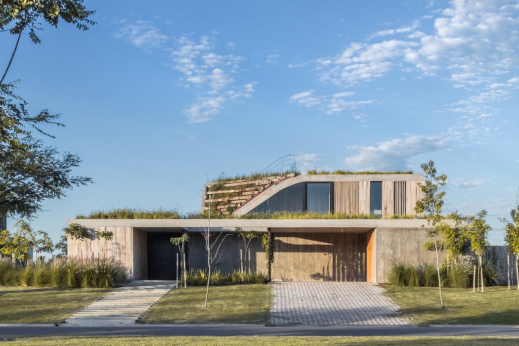 A modern, minimalist house with a green roof, large windows, and a wooden exterior.