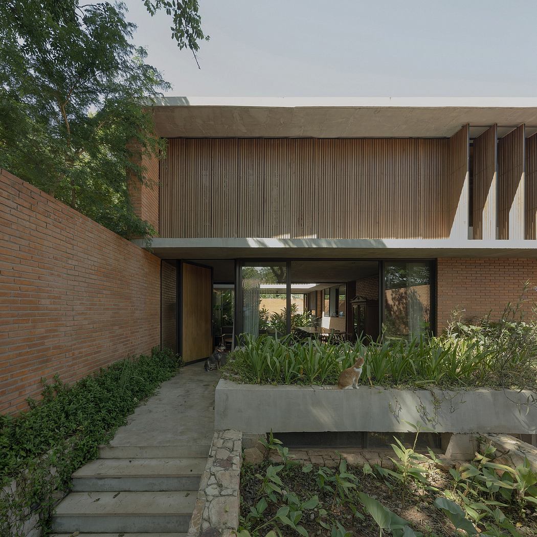 Modern brick and wood exterior with lush greenery surrounds the entrance.
