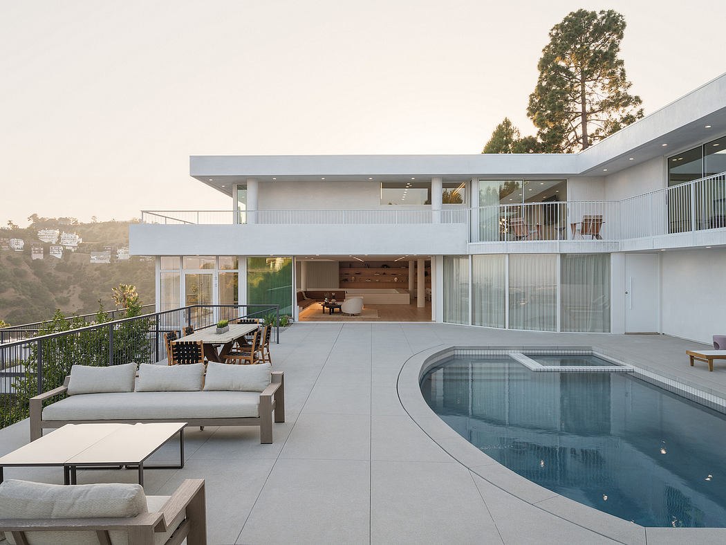 A modern home with a sleek, minimalist design featuring a swimming pool and outdoor lounge area.
