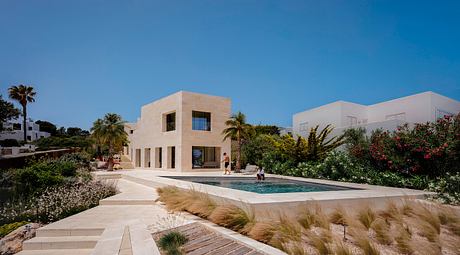 Modern Mediterranean-style villa with sleek exterior, lush landscaping, and inviting pool.