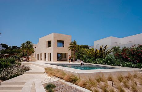 Modern Mediterranean-style villa with sleek exterior, lush landscaping, and inviting pool.