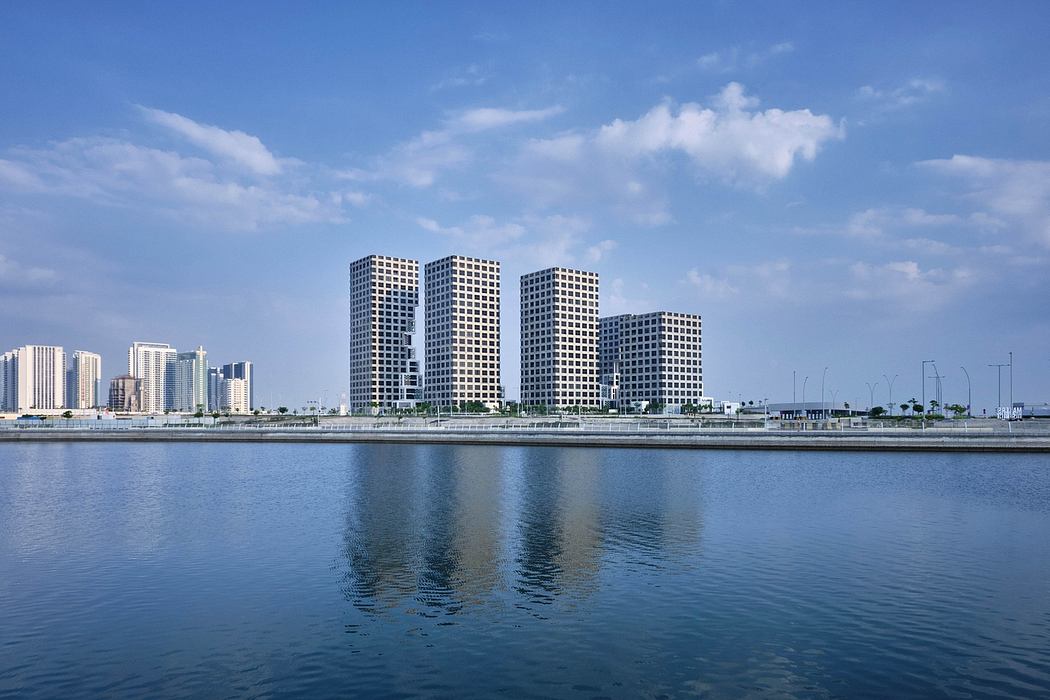 Towering skyscrapers with striking architectural designs reflected in the calm waters.