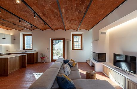 Brick vaulted ceiling, wood furnishings, and modern amenities in cozy living space.