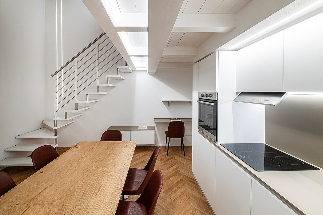 A sleek, modern kitchen with a long wooden dining table, steel stairs, and minimalist design.