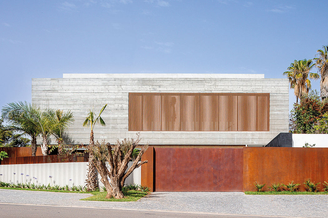 Striking modern architecture with textured concrete facade, wood paneling, and lush greenery.