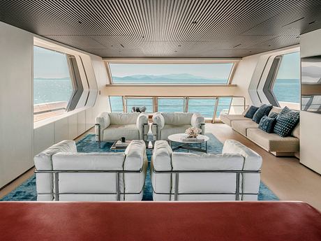 Sleek, modern interior with panoramic ocean views and plush seating arrangement.