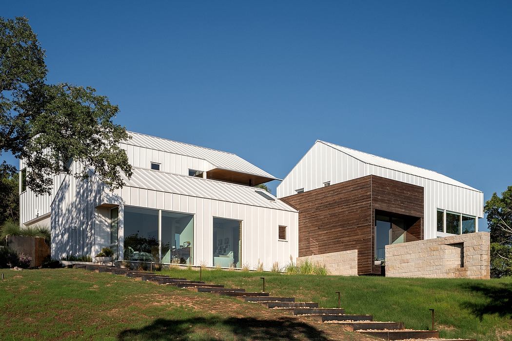 Modern multi-level home with pitched metal roofs, wood accents, and stepped entrance.