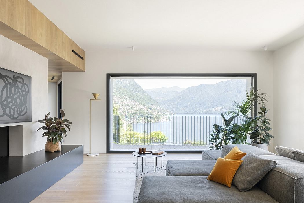 Minimalist living room with a wall-to-wall panoramic window overlooking a mountainous landscape.