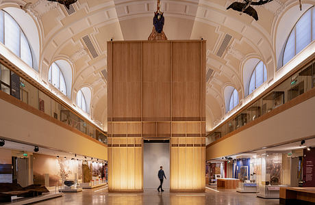 A grand, ornate interior with wooden architectural details and an expansive central hall.