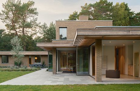 Modern single-story home with expansive glass walls, wood accents, and a covered patio.