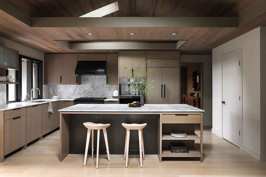 Sleek, modern kitchen with wood-paneled ceiling, marble countertops, and minimalist cabinetry.