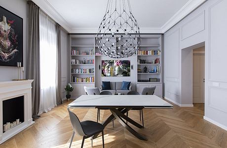 A sophisticated living room with a modern chandelier, built-in shelving, and herringbone wood floors.