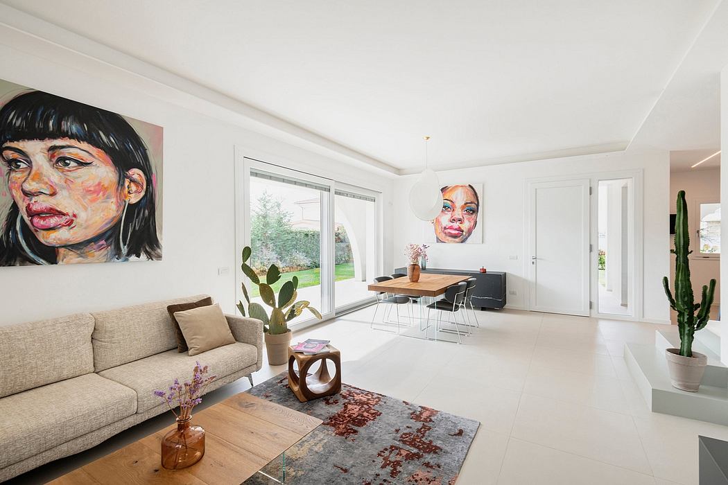 Bright, open-plan living space with large windows, minimalist furniture, and vibrant artwork.