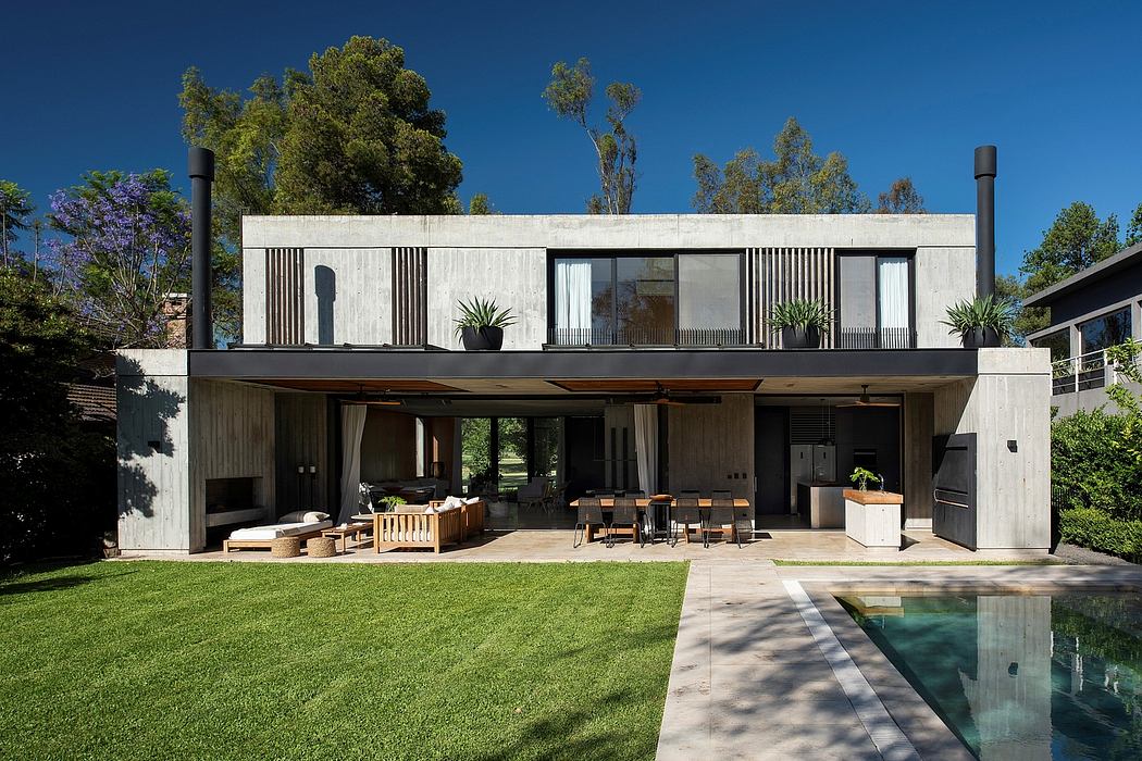 A modern, minimalist house with a large, open-plan living area, pool, and lush landscaping.