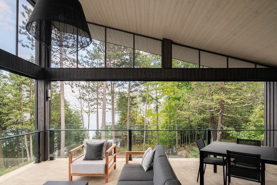 Large windows overlooking lush forest provide ample natural light in this modern, open-concept interior.