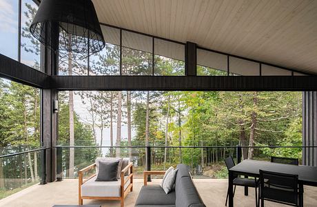 Large windows overlooking lush forest provide ample natural light in this modern, open-concept interior.