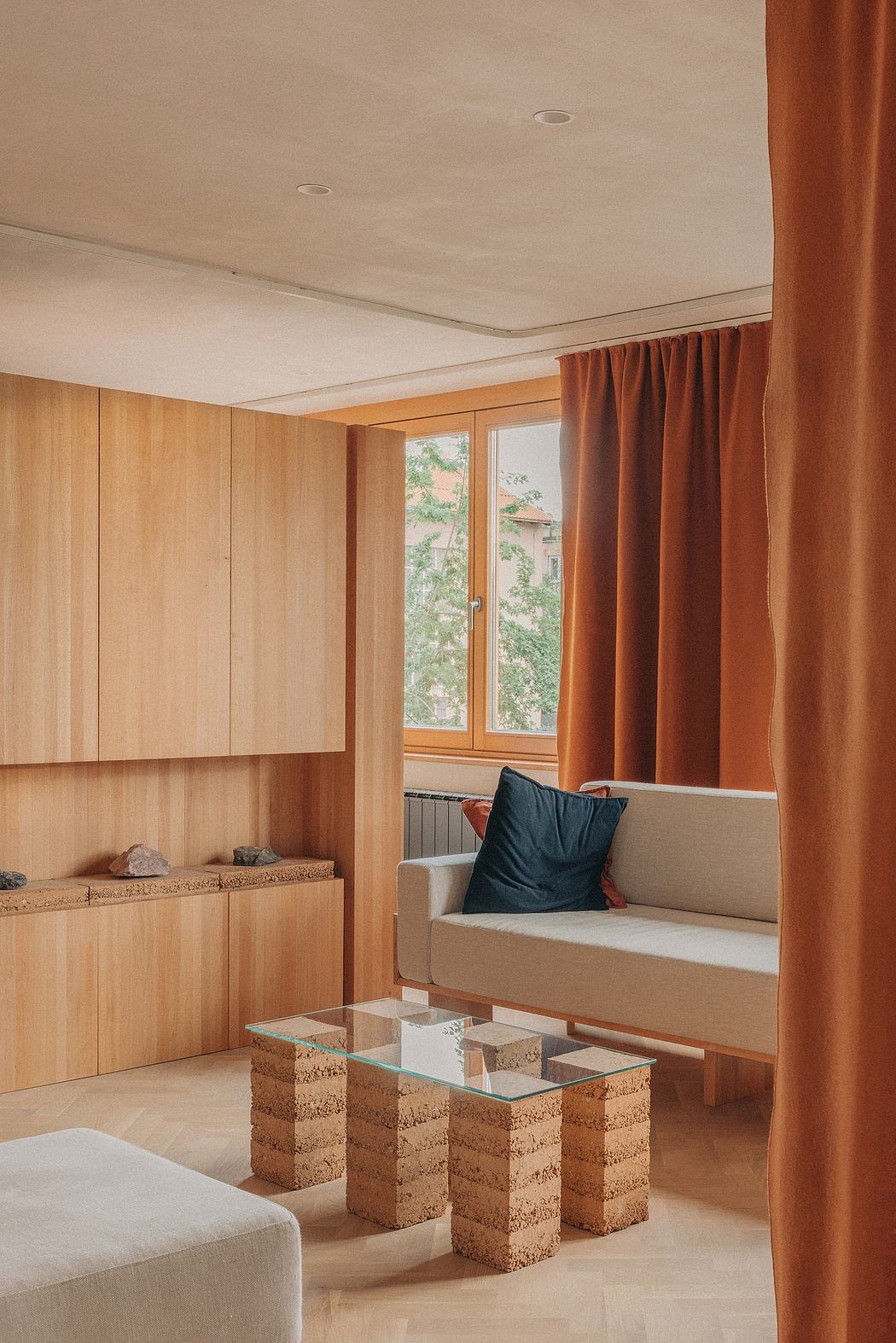 Cozy wooden interior with floor-to-ceiling windows, curtains, and a modern coffee table.