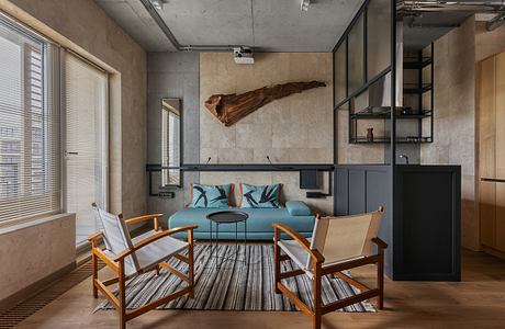 Minimalist living room with concrete walls, wooden furniture, and a striking driftwood accent.