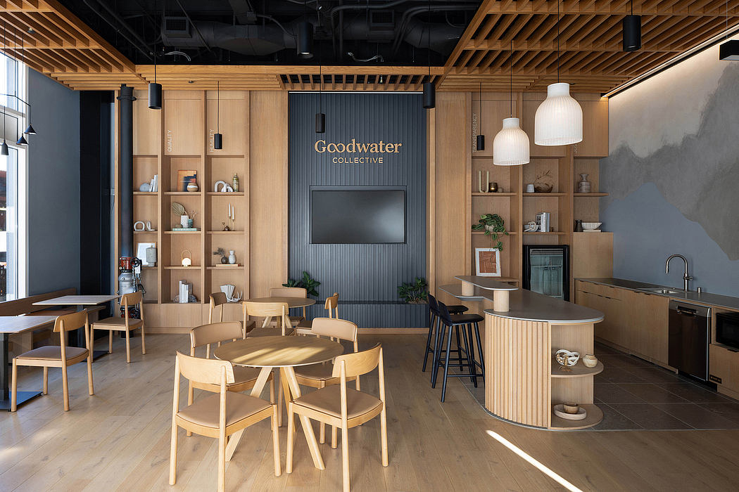 A modern workspace with wooden furnishings, gray accents, and a prominent Goodwater Collective sign.