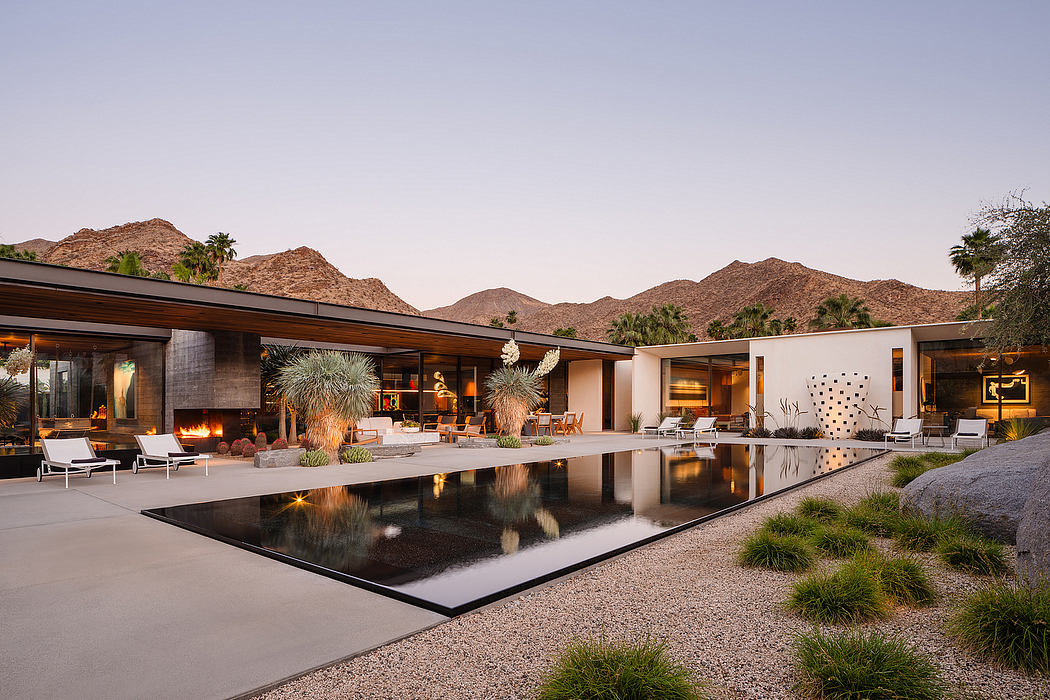 Modern desert estate with open-plan layout, infinity pool, and mountainous backdrop.