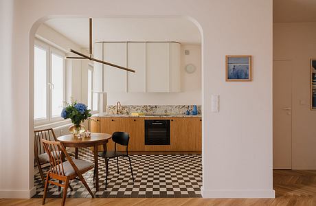 Minimalist kitchen with wooden cabinets, checkered floor, and a decorative light fixture.