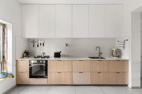 Minimalist kitchen with light-colored wood cabinets, sleek appliances, and a neutral color scheme.