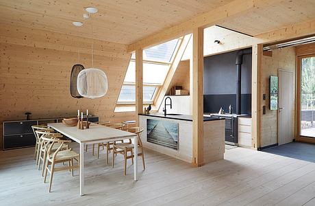 Spacious open-plan kitchen and dining area with wooden interior and large windows.