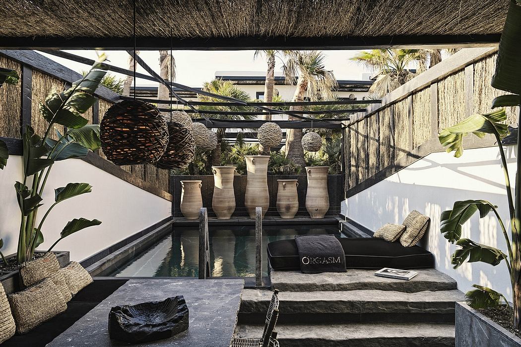 Lush tropical outdoor lounge with thatched roof, water feature, and modern decor.