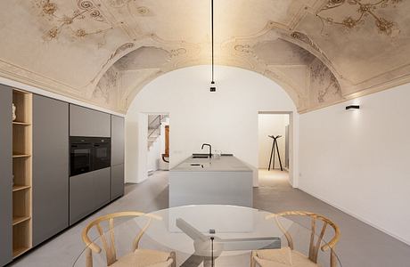 Ornate arched ceiling, contemporary kitchen with sleek cabinets, and minimalist furnishings.