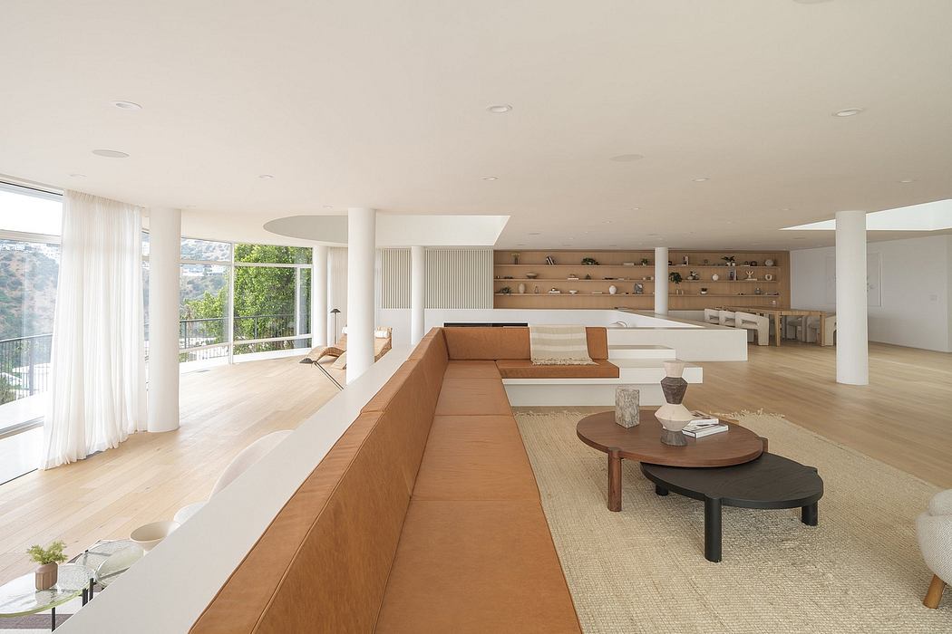 Spacious open-concept living room with modern furniture, natural materials, and expansive windows.