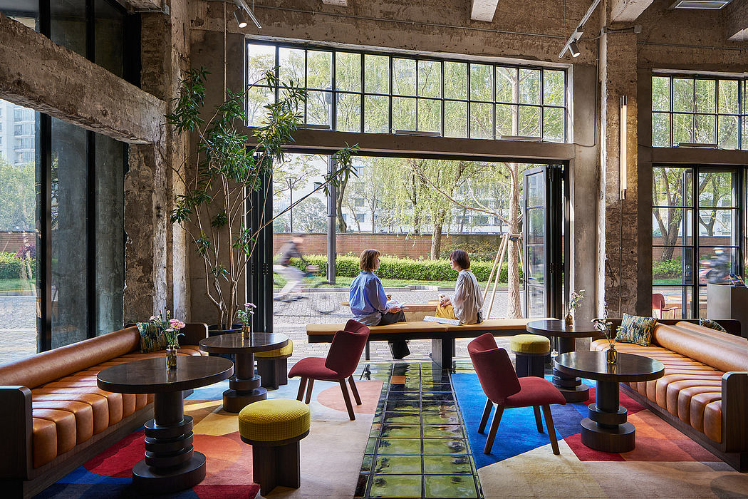 Vibrant industrial-style lounge with eclectic furnishings, large windows, and lush greenery.