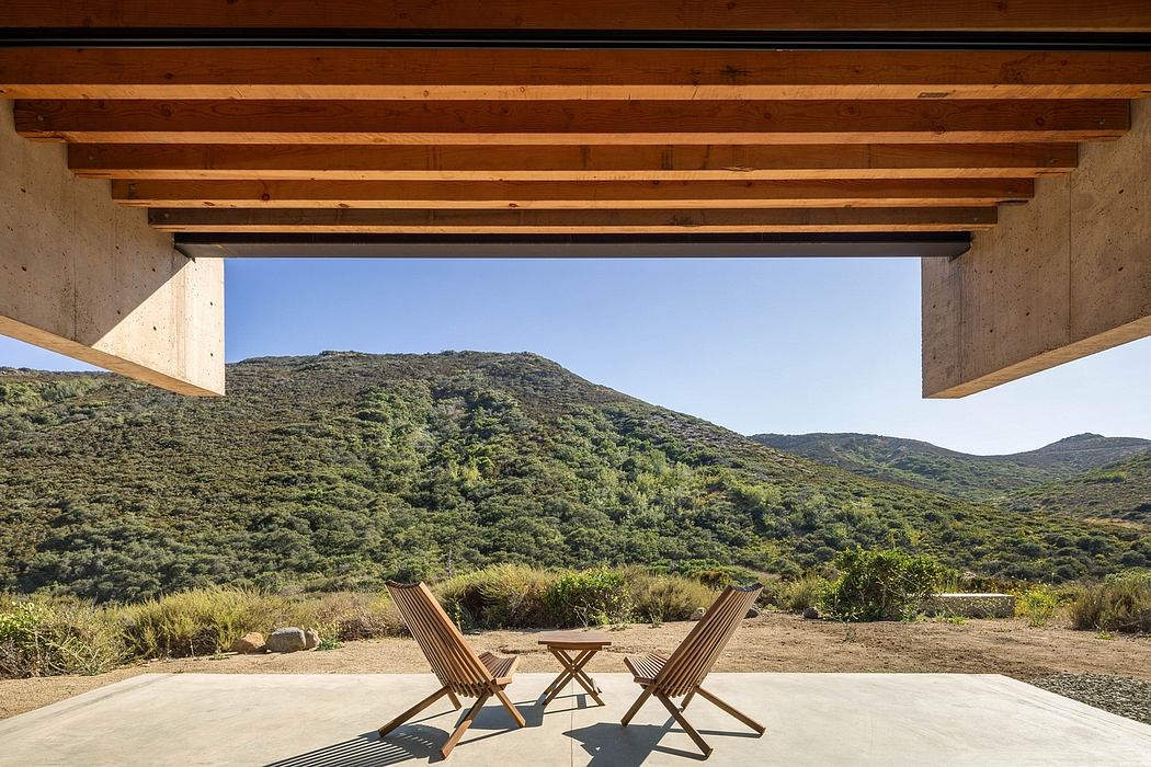 Rustic wooden beams frame a scenic mountain vista, inviting outdoor relaxation.