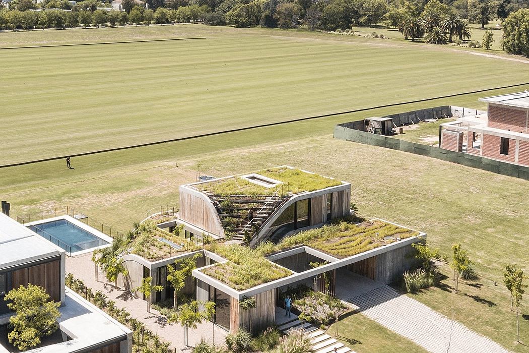 Stunning architectural design with green roofs, landscaping, and a vast open lawn.