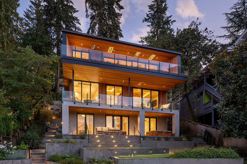 A modern, multi-story home with wooden siding, large windows, and a spacious balcony.