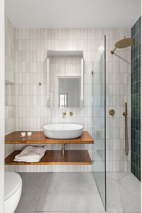 A modern, minimalist bathroom with clean lines, wood accents, and a freestanding vanity.