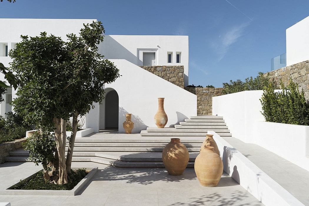 Minimalist Mediterranean architecture with ornate pottery and lush greenery.
