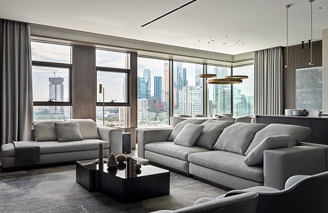 Spacious living room with floor-to-ceiling windows, modern furniture, and city skyline view.