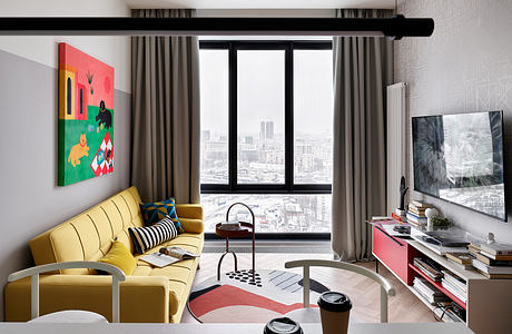 Stylish living room with modern furniture, vibrant artwork, and panoramic city view.