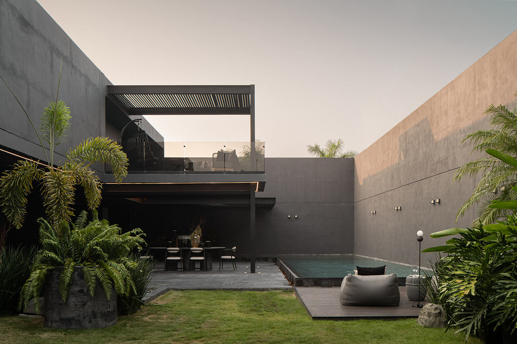 Sleek, modern outdoor living space with pool, covered dining area, and tropical foliage.