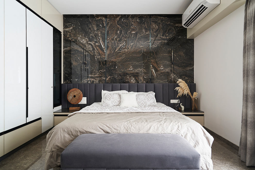 Modern, minimalist bedroom with striking black marble accent wall, plush gray upholstered headboard, and sleek built-in nightstands.