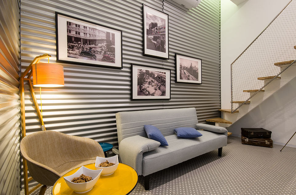 Cozy living room with retro photography, gray sofa, yellow table, and industrial-style decor.