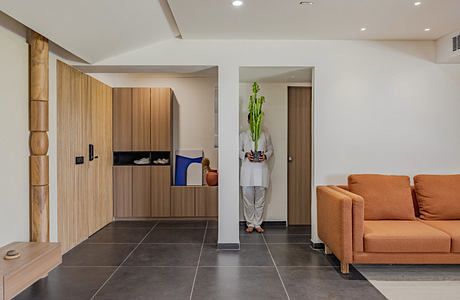 Modern, open-plan living space with wooden cabinetry, textured walls, and a neutral color palette.