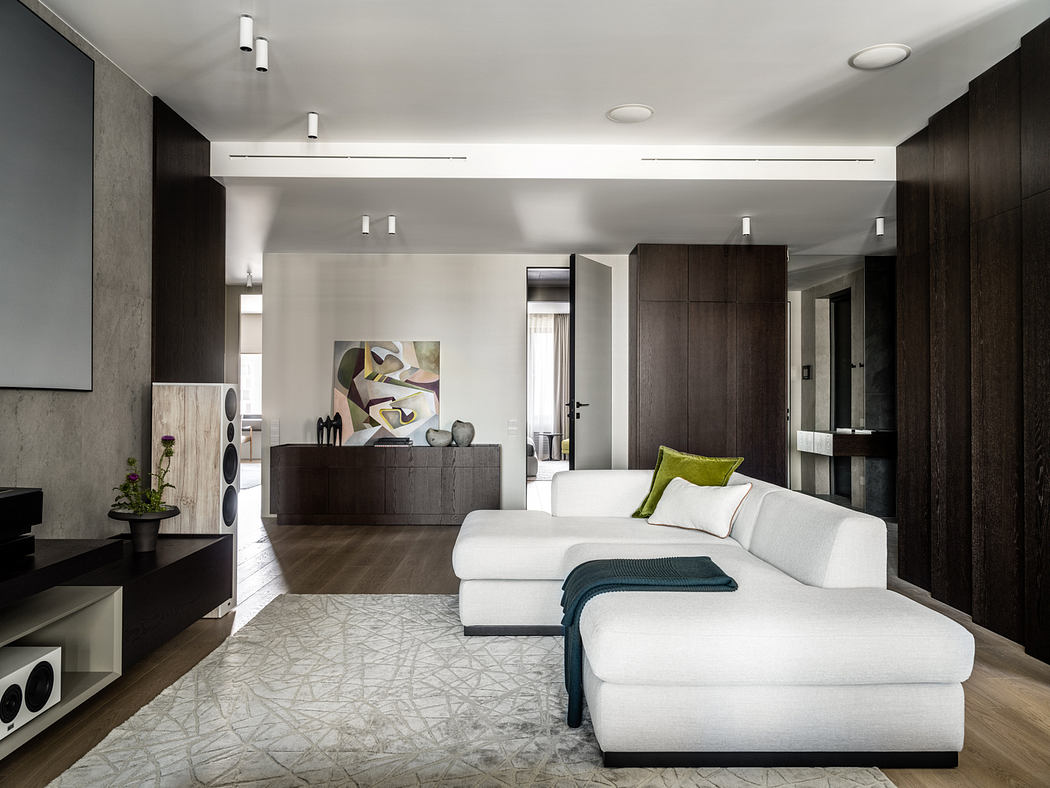 Sleek, modern living room with dark wood cabinets, white sofa, and abstract artwork.