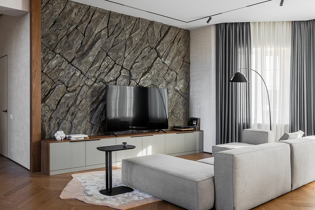 Sleek, contemporary living room with a striking stone accent wall, minimalist furniture, and hardwood flooring.